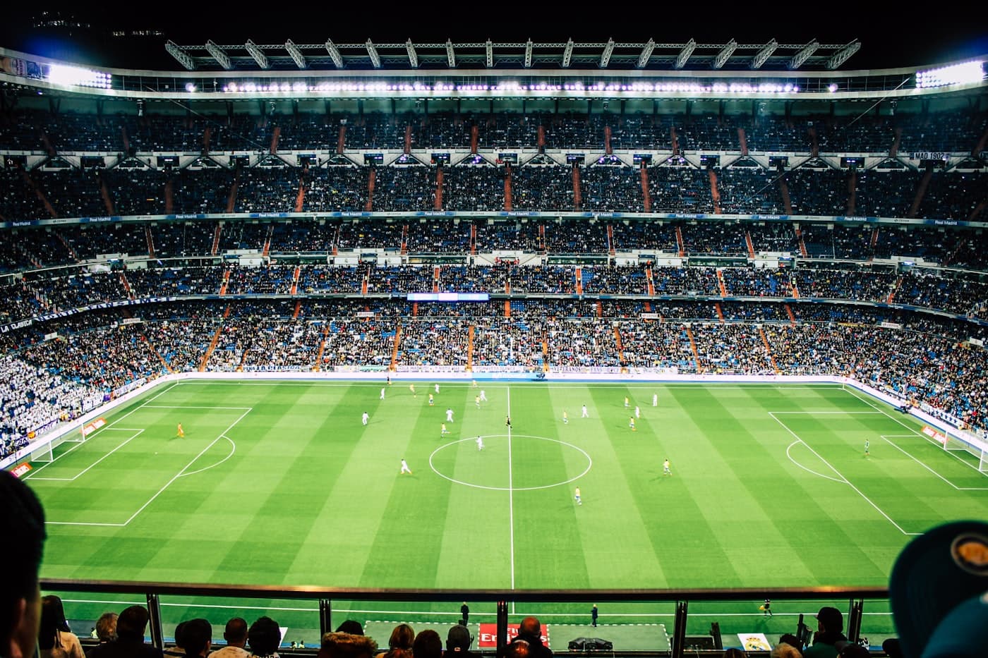 A packed football stadium under the lights